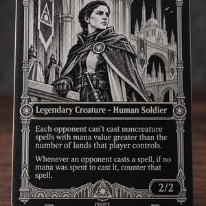 以下が含まれることがあります： 「Lavinia, Azorius Renegade」と題された白黒の金属製トレーディングカード。マントを羽織った兵士のイラスト、建築のディテール、ゲームルールを説明するテキストが記載されています。伝説のクリーチャー・人間・兵士のカードです。