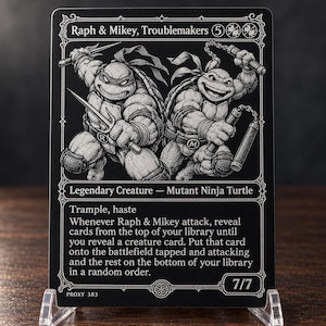Könnte beinhalten: Eine rechteckige schwarz-weiße Sammelkarte mit einer Illustration von zwei anthropomorphen Schildkröten, eine mit Sai-Dolchen und die andere mit Nunchakus. Der Kartentext lautet Raph & Mikey, Troublemakers, Legendary Creature, Mutant Ninja Turtle, 7/7.