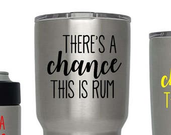 May include: Three stainless steel tumblers with the text "There's a chance this is rum" in different colors. The tumblers are from the Yeti brand.