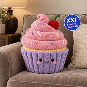 Peut inclure: Un jouet cupcake en crochet pelucheux avec une base violette côtelée ornée d'un visage souriant, une section centrale jaune et un dessus rose en spirale décoré de vermicelles colorés et d'une cerise rouge. Un badge bleu indique XXL CROCHET PATTERN.