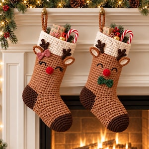May include: Two crocheted Christmas stockings shaped like reindeer, featuring tan bodies, dark brown heels and toes, and cream-colored cuffs. Each stocking has a red nose, embroidered eyes, and antlers. One has a pink bow, the other a green bow.