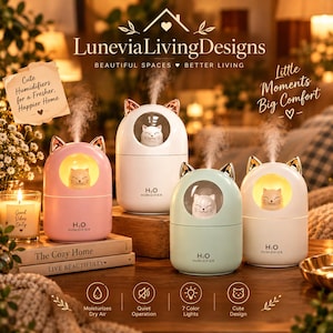 May include: Four H2O Humidifier units in pink, white, and light green, each featuring a cat-shaped figure inside a circular window, gold-colored cat ears on top, and a mist output. The devices are displayed with text branding and icons.