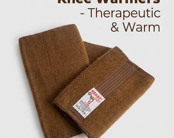 Könnte beinhalten: Ein Paar knie-wärmer aus kamelwolle in braun mit gerippter textur. Der text Camel Wool Knee Warmers - Therapeutic & Warm ist sichtbar. Ein weißes etikett mit dem markennamen NEBAT und einer kamelgrafik ist am stoff befestigt.