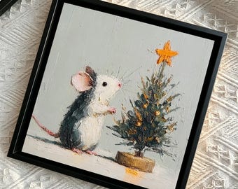 May include: A square framed oil painting on canvas featuring a small grey and white mouse standing next to a miniature Christmas tree. The tree is decorated with gold accents and topped with an orange star, all set against a light grey background.