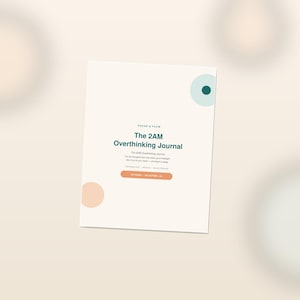 May include: A rectangular journal with a cream-colored cover featuring the text "The 2AM Overthinking Journal" in dark green. The cover includes a light blue circle with a dark green center, a peach circle, and a peach horizontal pill-shaped button.