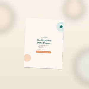May include: A white rectangular menu planner titled The Dopamine Menu Planner in dark green text. The cover features a small teal circle in the top right, a peach circle in the bottom left, and a peach horizontal pill-shaped button with text.