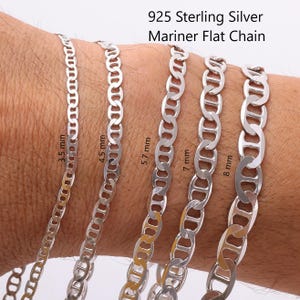May include: Five 925 sterling silver mariner flat chains of varying widths, labeled 3.5 mm, 4.5 mm, 5.7 mm, 7 mm, and 8 mm. The silver chains feature oval links with a central bar, displaying a polished metallic finish against a skin-toned background.