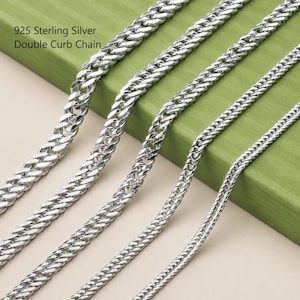 May include: Four 925 Sterling Silver double curb chains of varying thicknesses arranged in a parallel diagonal line. Each chain features a polished metallic finish with interlocking oval links that create a dense, textured appearance.