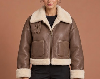 Chaqueta de aviador de piel color topo de corte recto para mujer con forro de piel sintética color crema.