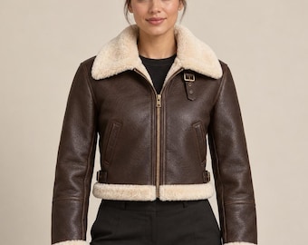 Chaqueta corta de aviador de cuero marrón para mujer con forro de piel sintética color crema.