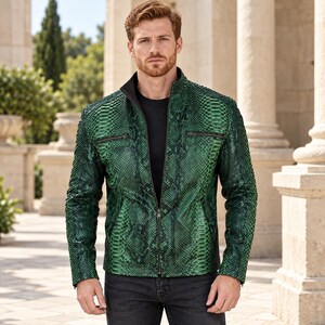 Peut inclure: Une veste vert vif pr&eacute;sentant un motif textur&eacute; en peau de serpent, un col montant et une fermeture &eacute;clair centrale sur le devant. Le v&ecirc;tement comprend deux poches poitrine zipp&eacute;es horizontales et est port&eacute; sur un t-shirt noir et un jean fonc&eacute;.