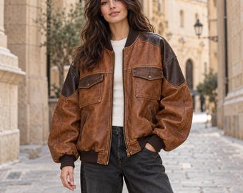 Cognacbruine, verweerde leren bomberjack voor dames, oversized model in utility-stijl.
