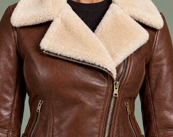 Chaqueta de aviador de piel color castaño para mujer con forro de piel sintética y cinturón.