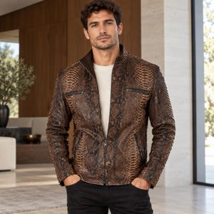 Peut inclure: Une veste en cuir &agrave; motif peau de serpent marron et noir avec un col montant, une fermeture &eacute;clair frontale int&eacute;grale et deux poches poitrine zipp&eacute;es horizontales, port&eacute;e sur un haut blanc et un pantalon noir.