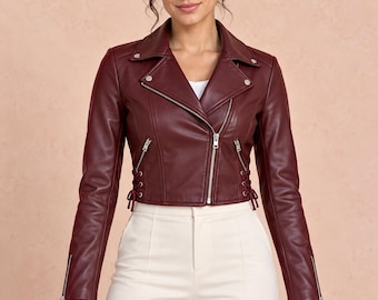 Chaqueta de cuero corta estilo motero para mujer, color burdeos, con paneles laterales ajustables en la cintura.