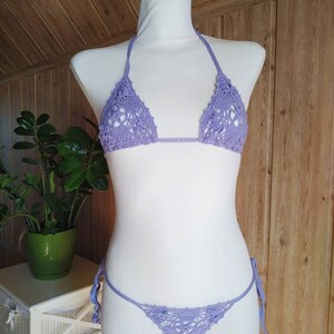 May include: A lavender crochet bikini top and bottom with a delicate floral pattern.