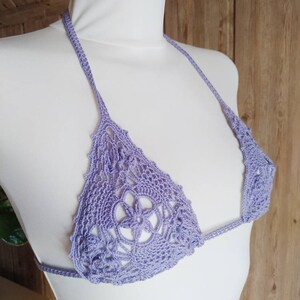 May include: A lavender crochet bikini top with a floral design.