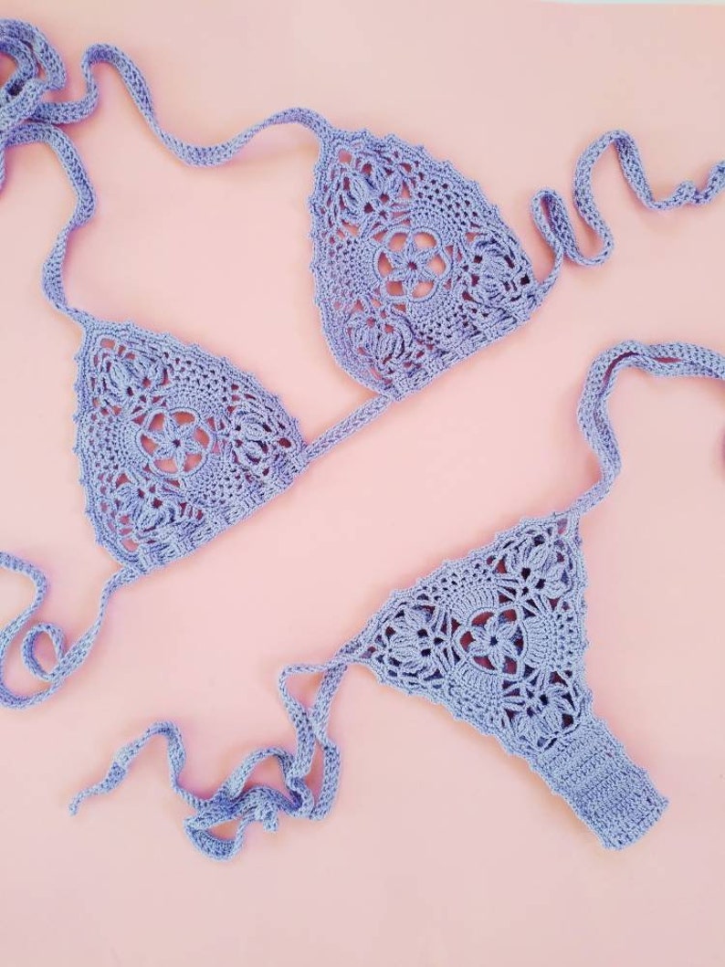 May include: A lavender crochet bikini top and bottom with a delicate floral pattern. The bikini is made with a soft, lightweight yarn and has adjustable straps.