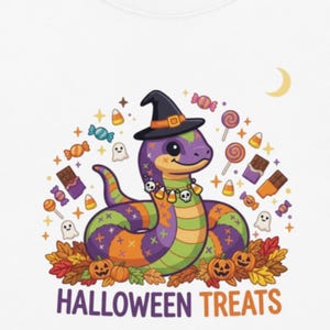 Può includere: Una t-shirt bianca a maniche corte con la grafica di un serpente viola e verde che indossa un cappello da strega nero e una collana di teschi. Il disegno include caramelle colorate, piccoli fantasmi, zucche, foglie autunnali e HALLOWEEN TREATS.