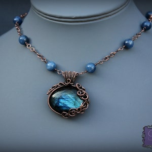 May include: A copper wire wrapped pendant necklace with a blue labradorite gemstone and a chain of blue beads.