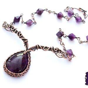 May include: An amethyst necklace with a large teardrop pendant wrapped in copper wire. The necklace features a delicate chain with smaller amethyst stones.