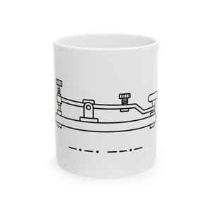 Peut inclure: Un mug en céramique blanche orné d'une illustration au trait noir représentant un manipulateur télégraphique centré sur la face avant. Sous le graphique, une séquence de points et de traits en code Morse est imprimée en encre noire.