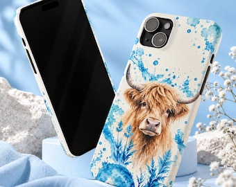 May include: A smartphone case featuring a watercolor illustration of a brown Highland cow with long horns, surrounded by blue paint splatters and blue floral elements on a cream background, shown with a phone screen facing forward.