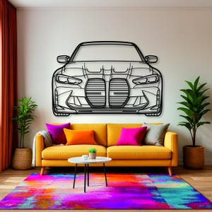 Op de afbeelding: Een zwart metalen wandkunstwerk met het vooraanzicht van een auto met een opvallend dubbel grille-ontwerp, hoekige koplampen en gedetailleerde bumperlijnen, gemonteerd op een muur boven een gele bank met kleurrijke kussens.
