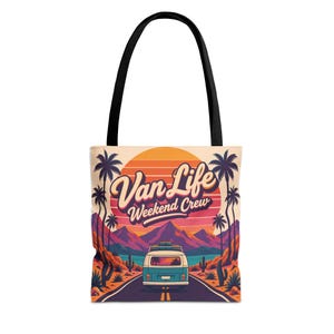 May include: A tote bag with black handles featuring a graphic print of a blue van on a road leading toward mountains under a large orange sun. The text Van Life Weekend Crew is printed in a stylized font above the van, surrounded by palm trees.