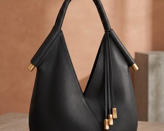 Minimalistische schwarze Lederhandtasche, schlichter Luxus, geometrische, beschwerte Quasten