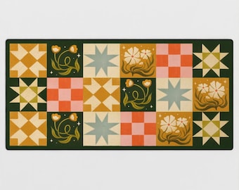 May include: A rectangular mat featuring a grid of squares with alternating patterns including eight-pointed stars, checkered blocks in pink and orange, and floral illustrations with white flowers and green stems on a dark green background.