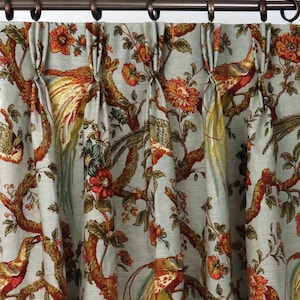 Puede incluir: Cortinas con fondo azul y un patrón de pájaros y flores de color naranja, rojo y verde.