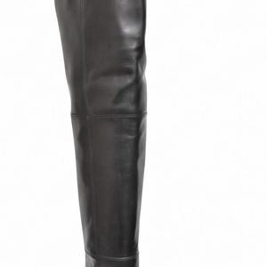 May include: A black leather over-the-knee boot featuring a smooth finish, a pointed toe, and a slim high heel. The boot has a structured shaft that extends above the knee with visible vertical seam detailing along the side and a clean silhouette.