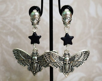 May include: Silver skull dangle earrings with black star charms and silver moth pendant charms.