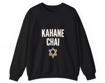 May include: A black long-sleeve sweatshirt featuring the white text KAHANE CHAI printed in a bold, sans-serif font. Below the text is a white Star of David symbol with a light tan shadow effect, centered on the chest area.