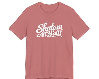 May include: A dusty rose short-sleeved t-shirt featuring the white text Shalom All Y'all! printed in a cursive script font across the center of the chest. The garment has a crew neckline and a standard fit with short sleeves.