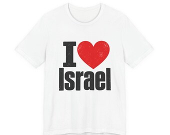May include: A white short-sleeved t-shirt featuring a graphic print on the chest. The design includes a black letter I, a red heart symbol with a distressed texture, and the word Israel in bold black capital letters below the heart.