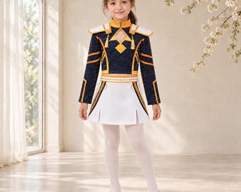 May include: A two-piece outfit consisting of a dark navy blue long-sleeved cropped top with gold trim, shoulder epaulets, and a cutout neckline, paired with a white pleated skirt featuring gold accents and a white belt with metallic studs.