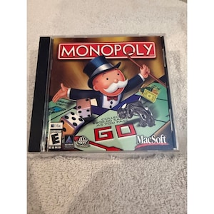 May include: A Monopoly board game software case for Mac featuring the iconic character Rich Uncle Pennybags in a top hat and tuxedo, holding a cane. The cover displays dice, a game piece, a ten-dollar bill, and the text Collect $200.00 Salary As You Pass Go.