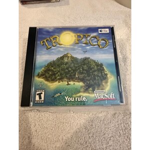 May include: A Tropico video game jewel case for Mac featuring a tropical island illustration with a bright sun, a small airplane, and a boat. The cover includes the text Tropico, You rule, Mac, MacSoft, Infogrames, and a Teen ESRB rating symbol.