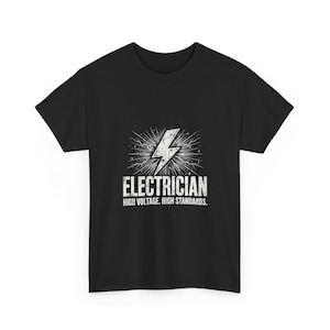 May include: A black short-sleeve t-shirt featuring a white graphic of a lightning bolt with radiating lines. Below the bolt, the text reads "ELECTRICIAN" in large capital letters, followed by the phrase "HIGH VOLTAGE. HIGH STANDARDS."