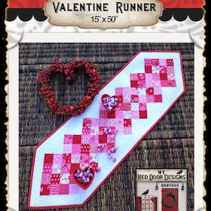 May include: Valentine's Day table runner with a pink and red patchwork design. The runner is 15 inches by 50 inches and features a heart-shaped design. The runner is displayed on a woven brown surface with a heart-shaped wreath and candy dishes.
