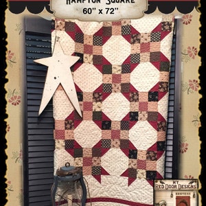 Puede incluir: Una colcha Hampton Square de 152 cm por 183 cm, con un patrón geométrico repetitivo en crema, burdeos y marrón oscuro con intrincadas costuras florales. Una gran estrella de color crema con aspecto desgastado cuelga a la izquierda.