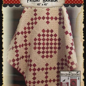 May include: A quilt titled Friday Harbor measuring 45 inches by 45 inches. The quilt features a cream-colored fabric with a subtle swirling pattern and a repeating geometric design of small, dark red squares arranged in a grid-like pattern.