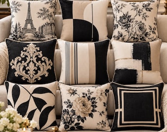 May include: A collection of nine square throw pillows featuring a black, white, and beige color palette. Designs include the Eiffel Tower, floral patterns, geometric shapes, vertical stripes, damask motifs, and abstract brushstrokes.