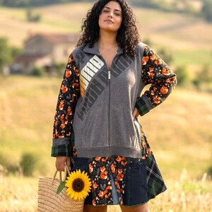 May include: A zip-up jacket featuring a grey torso with a diagonal Puma logo, long sleeves with an orange fox pattern on a black background, and a flared lower section combining the fox print, dark denim panels, and green plaid fabric accents.