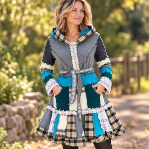 May include: A hooded coat featuring a patchwork design with various textures and patterns in shades of grey, teal, cream, and tan. The coat includes a tie-waist belt, long sleeves, two front pockets, and a flared hemline with visible stitching.