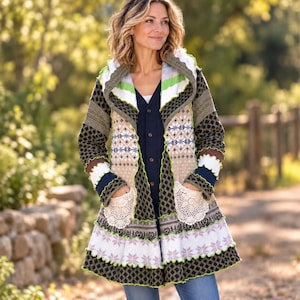 May include: A long-sleeved hooded cardigan featuring a patchwork design with various knit patterns in olive green, beige, white, and navy blue. The garment includes two front pockets with cream-coloured lace detailing and a ruffled hemline.