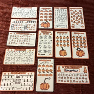 Pode incluir: Uma coleção de onze cartões retangulares de papel para desafios de poupança com ilustrações de abóboras e texto, incluindo títulos como Pumpkin Fun, Pumpkin Patch e Pumpkin Chunkin. Cada cartão contém fileiras de abóboras para colorir ao poupar.