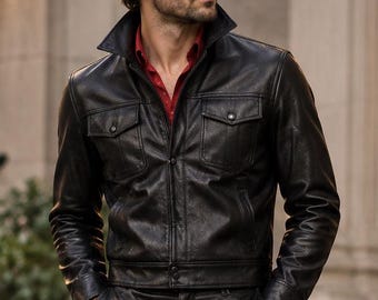 May include: A black leather jacket with two chest pockets and a front zipper, worn over a red collared shirt, paired with matching black leather trousers and black leather boots, accessorized with dark-tinted aviator sunglasses.